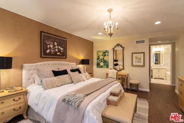 bedroom with dark hardwood / wood-style flooring, an inviting chandelier, and connected bathroom