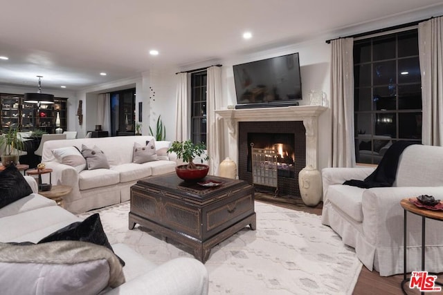 living room with crown molding and light hardwood / wood-style flooring