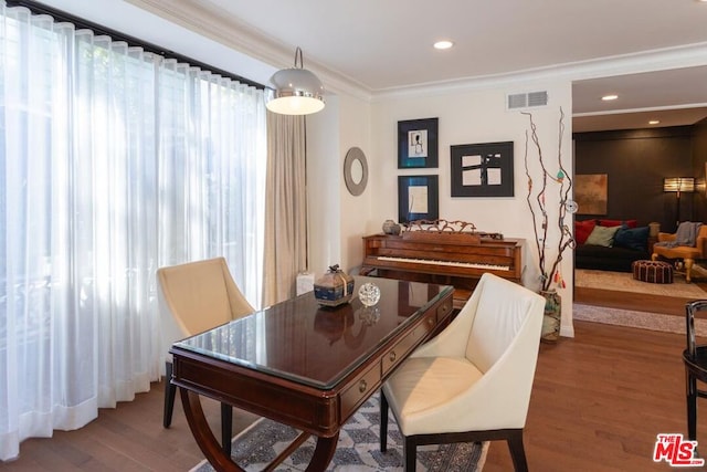 dining area featuring wood-type flooring and ornamental molding