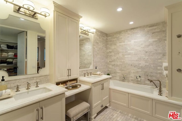 bathroom with decorative backsplash, tile patterned floors, a bathtub, and vanity