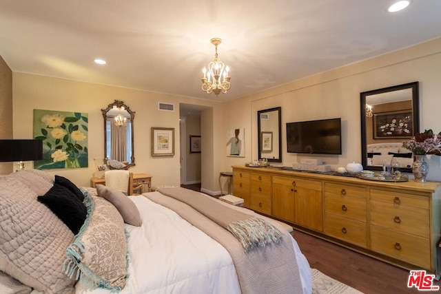 bedroom with dark hardwood / wood-style floors and a chandelier