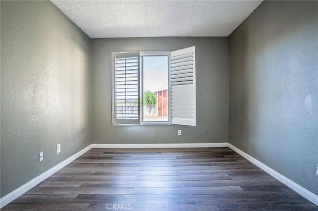 empty room featuring dark hardwood / wood-style floors and a textured ceiling