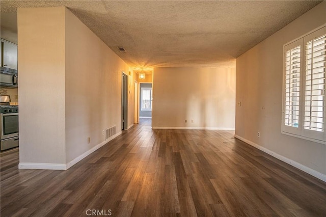 empty room featuring dark hardwood / wood-style floors and a textured ceiling