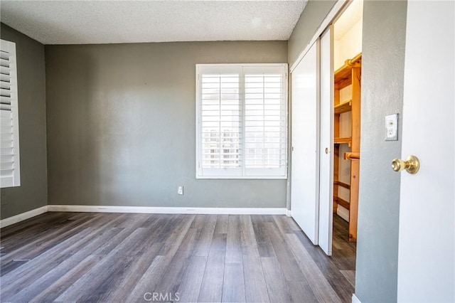 spare room with a textured ceiling and hardwood / wood-style floors