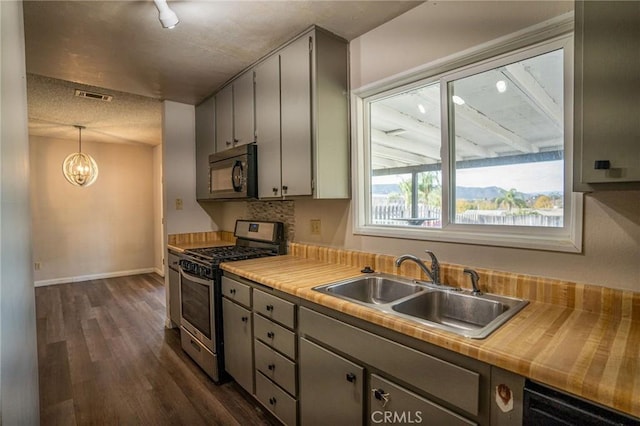 kitchen featuring decorative light fixtures, black appliances, sink, dark wood-type flooring, and gray cabinetry