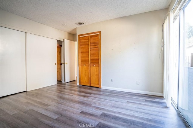 unfurnished bedroom with a textured ceiling and hardwood / wood-style flooring