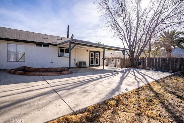 rear view of property featuring central AC unit and a patio area