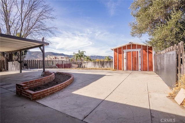 view of patio / terrace featuring a storage unit and a mountain view