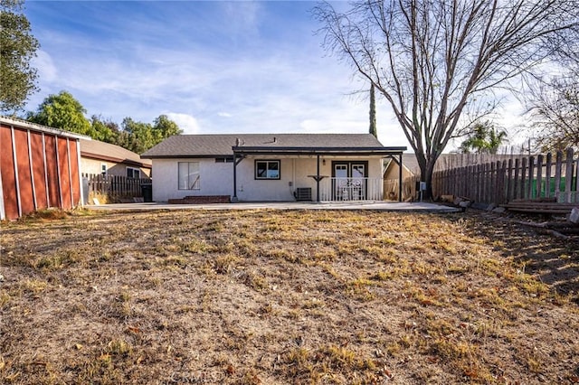 back of house featuring a lawn, french doors, and a patio