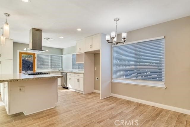 kitchen featuring island exhaust hood, white cabinetry, and hanging light fixtures