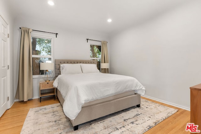 bedroom featuring multiple windows and light hardwood / wood-style flooring