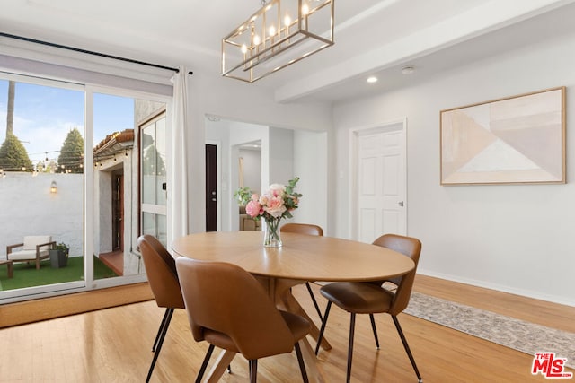 dining space featuring light hardwood / wood-style floors and a notable chandelier