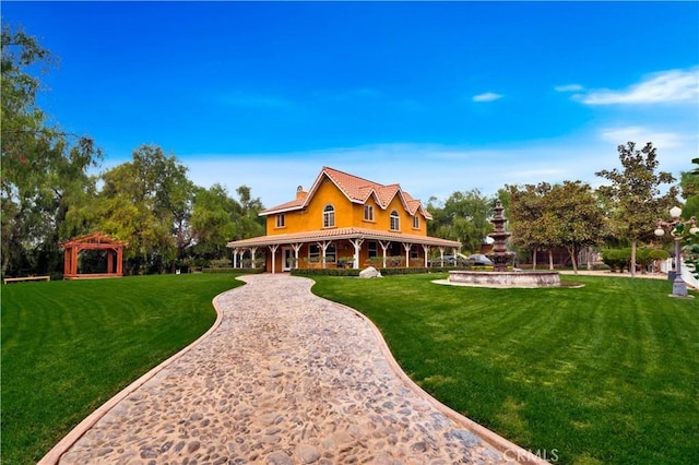 rear view of house with a lawn and a gazebo