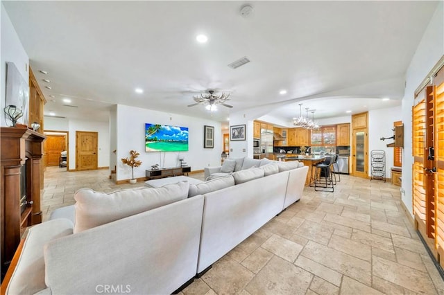 living room featuring ceiling fan with notable chandelier