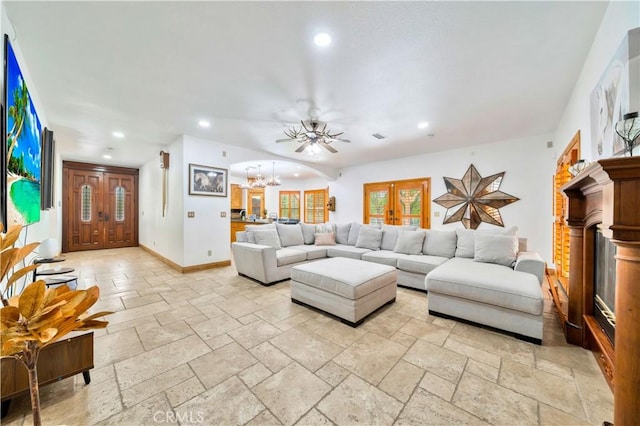 living room with ceiling fan with notable chandelier