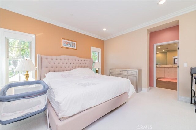 carpeted bedroom featuring multiple windows, ensuite bath, and ornamental molding