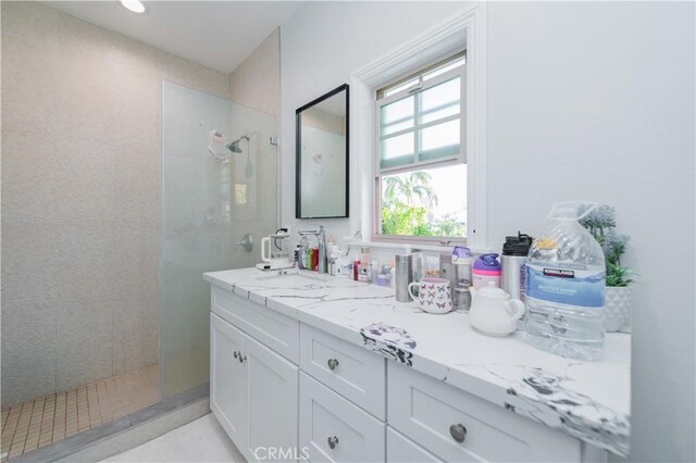 bathroom featuring tiled shower and vanity