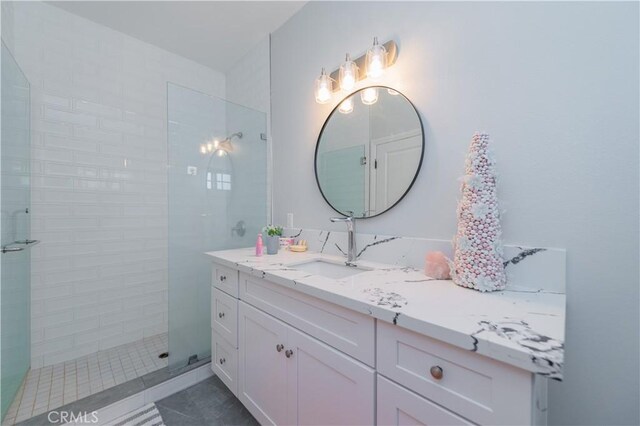 bathroom with vanity, tile patterned flooring, and tiled shower