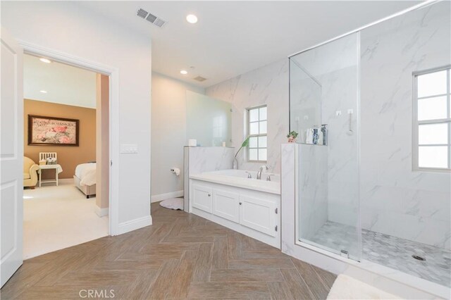 bathroom featuring a tile shower, a healthy amount of sunlight, and parquet floors