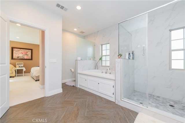 bathroom featuring a wealth of natural light, a marble finish shower, visible vents, and recessed lighting