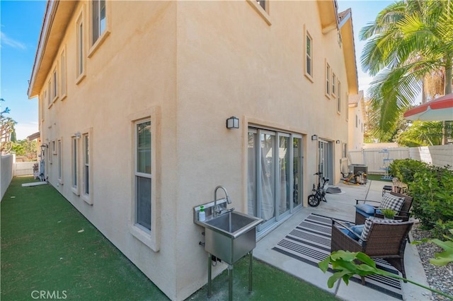 back of property featuring a fenced backyard, a patio, and stucco siding