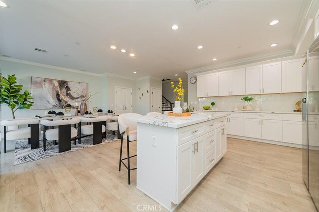 kitchen featuring a center island, light hardwood / wood-style floors, and white cabinets