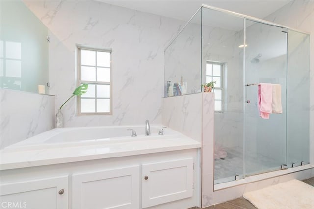 full bathroom with a healthy amount of sunlight, a marble finish shower, and a bath