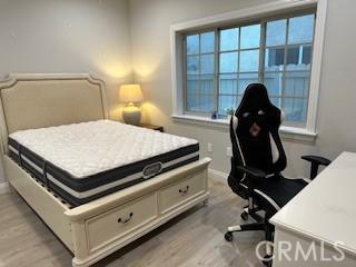 bedroom with light wood-type flooring and baseboards