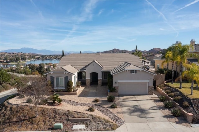 single story home with a water and mountain view and a garage