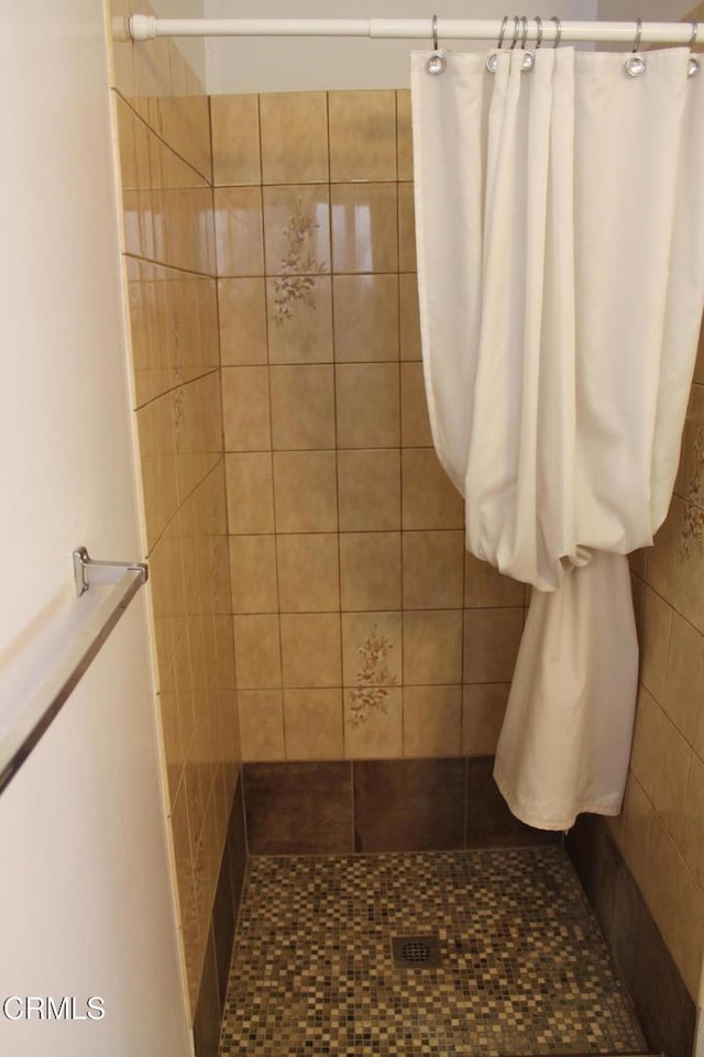 bathroom featuring tile patterned flooring and tiled shower