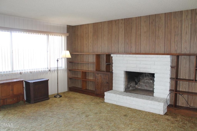 unfurnished living room with light carpet, a brick fireplace, and wooden walls