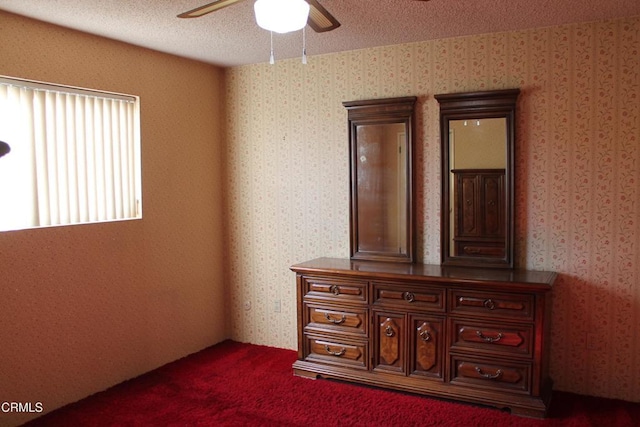 unfurnished bedroom featuring a textured ceiling, ceiling fan, and carpet floors