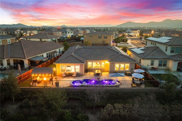 back house at dusk with an outdoor hangout area and a mountain view