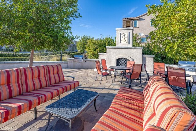 view of patio featuring area for grilling and an outdoor living space with a fireplace