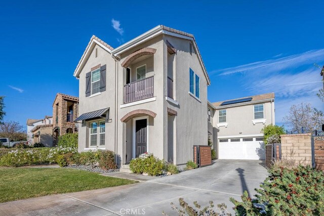 view of front of house featuring a garage, a balcony, a front yard, and solar panels