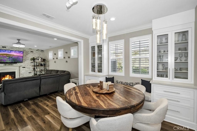 dining space with crown molding, a healthy amount of sunlight, and dark wood-type flooring