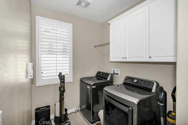 laundry area featuring separate washer and dryer and cabinets