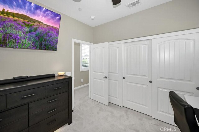 bedroom with ceiling fan, a closet, and light carpet