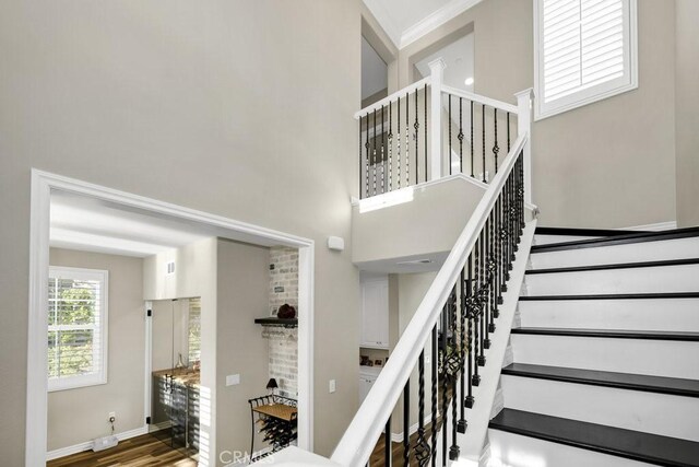 stairs featuring hardwood / wood-style flooring and a high ceiling