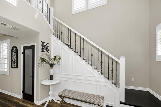 staircase with a high ceiling and hardwood / wood-style floors