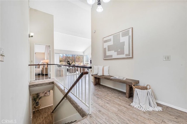 corridor featuring hardwood / wood-style flooring and high vaulted ceiling