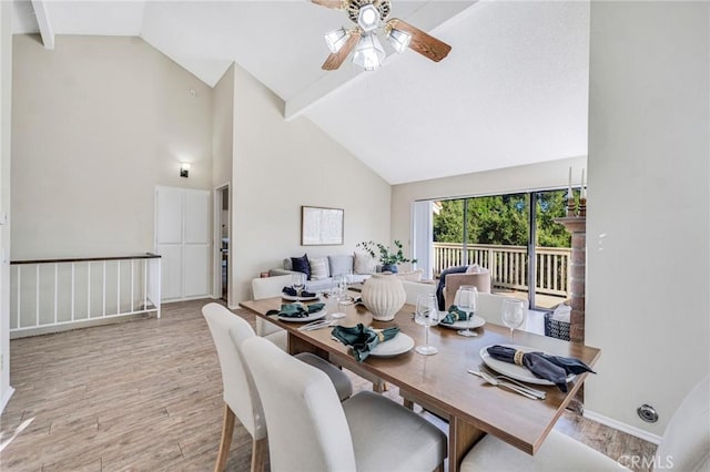 dining space featuring light hardwood / wood-style floors, high vaulted ceiling, beam ceiling, and ceiling fan