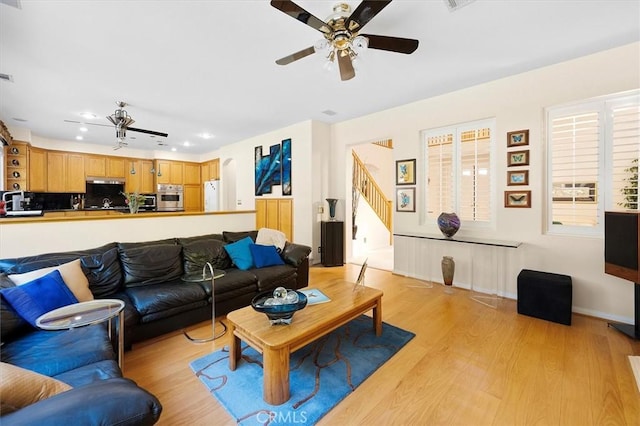 living room with light wood-type flooring and ceiling fan