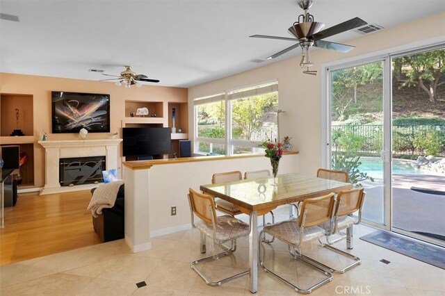 dining room featuring ceiling fan, built in features, and light tile patterned flooring