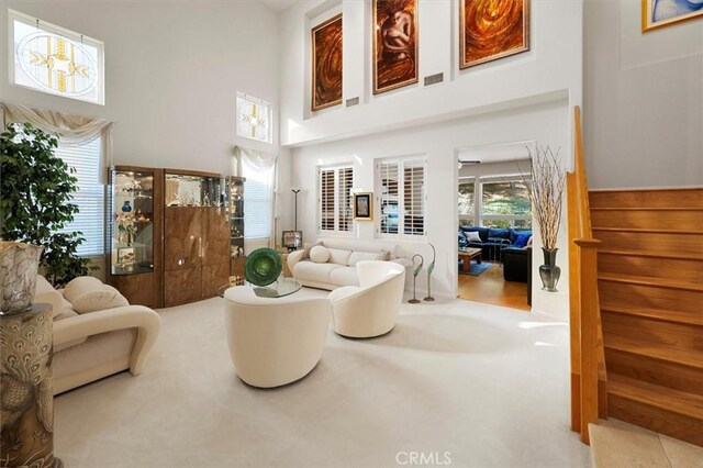 carpeted living room featuring a high ceiling