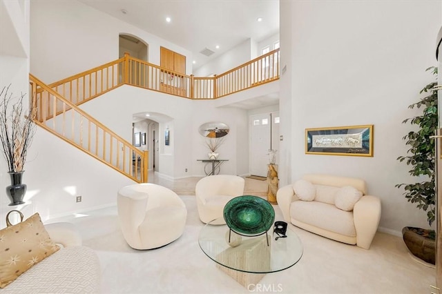 carpeted living room with a high ceiling