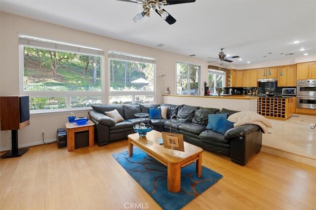 living room with ceiling fan and light hardwood / wood-style floors