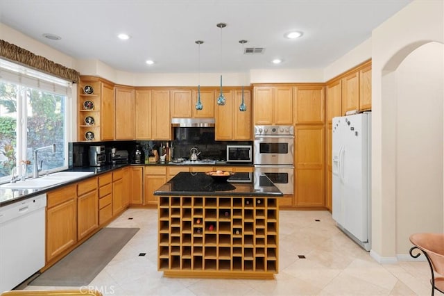 kitchen with decorative light fixtures, tasteful backsplash, a kitchen island, sink, and appliances with stainless steel finishes