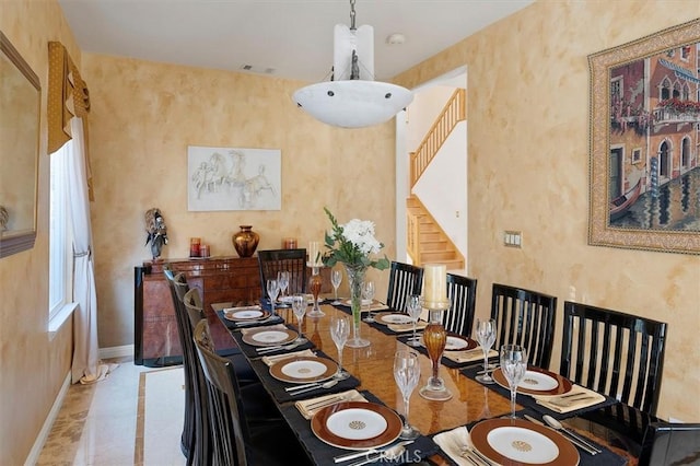 dining area featuring a towering ceiling