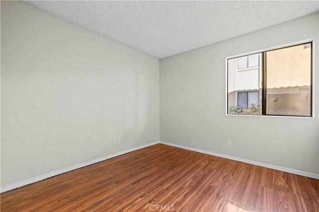 spare room with hardwood / wood-style floors and a textured ceiling